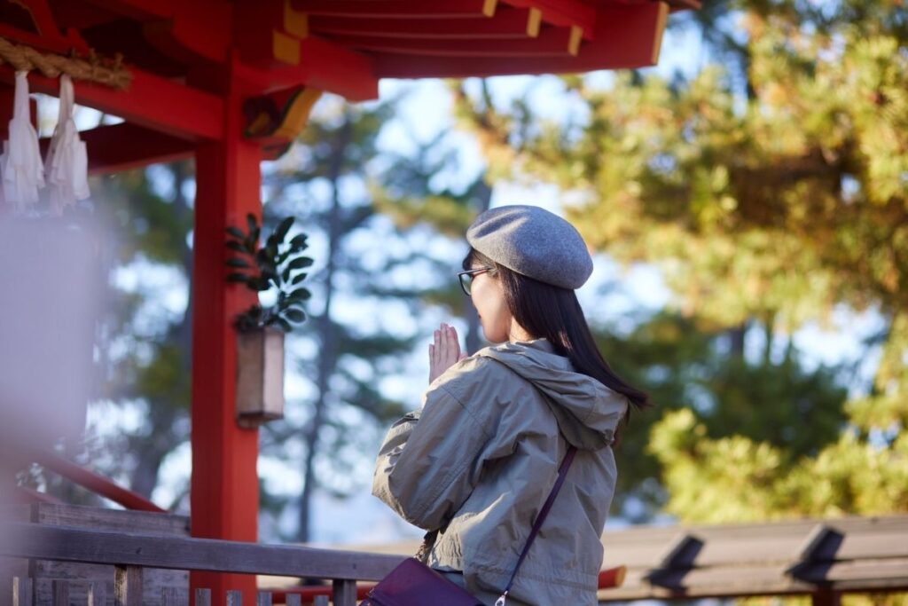 Visitors quietly praying at a Shinto shrine in Japan