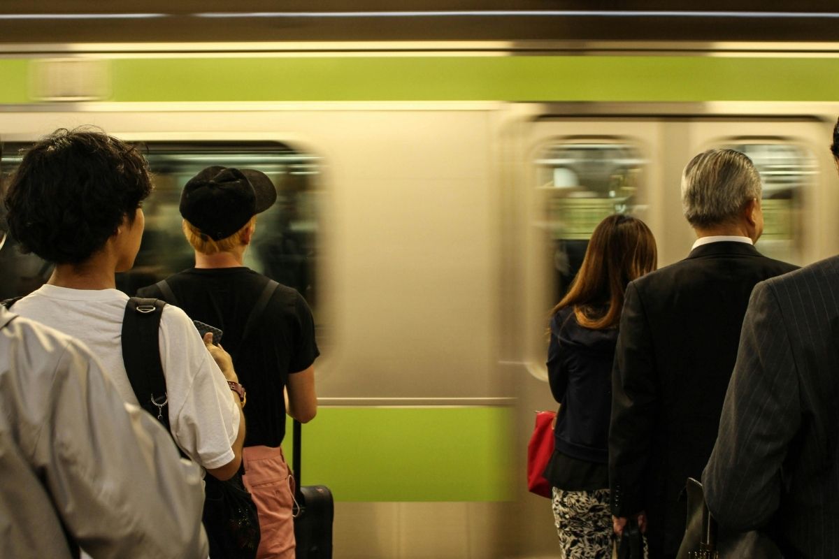 People quietly lining up at a train platform in Japan